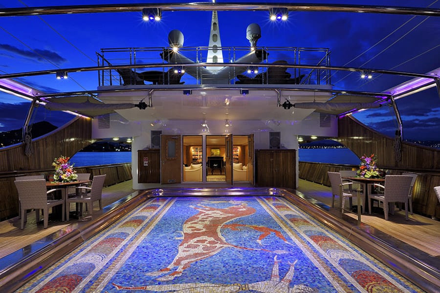 luxury yachts - imposing mosaic floor of yacht deck with view to living room by night
