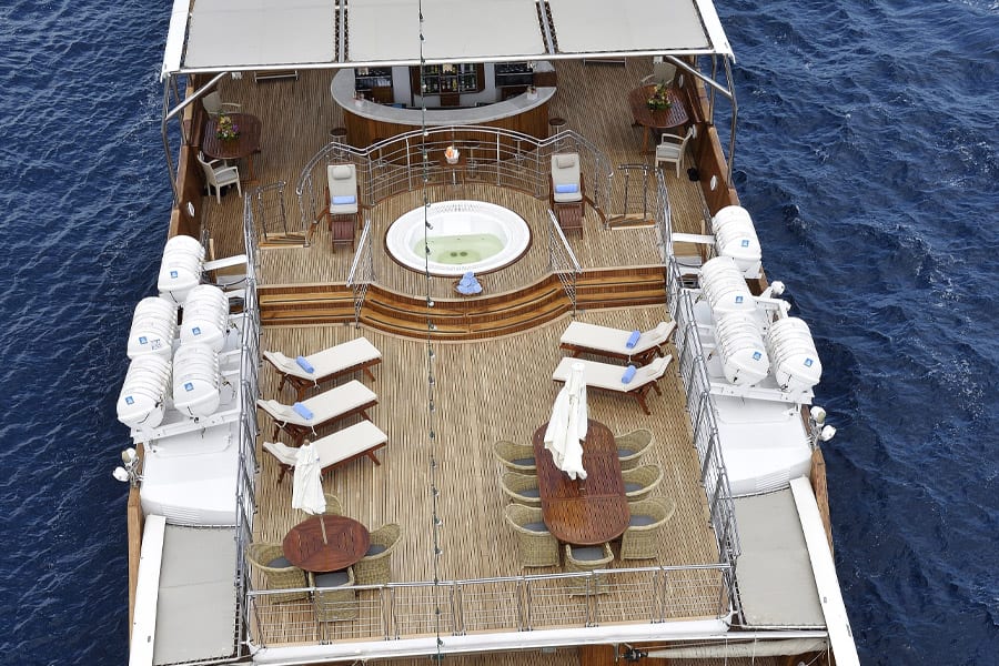 luxury yachts - drone shot of yacht with tables and whirlpool with bar