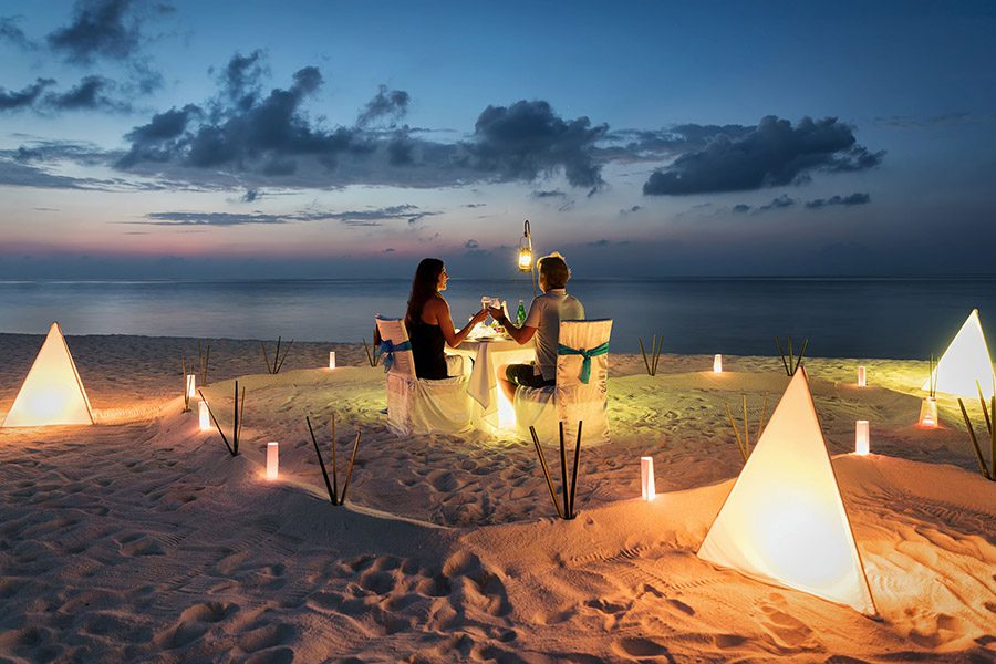 luxury experiences - couple romantic dinner at the beach