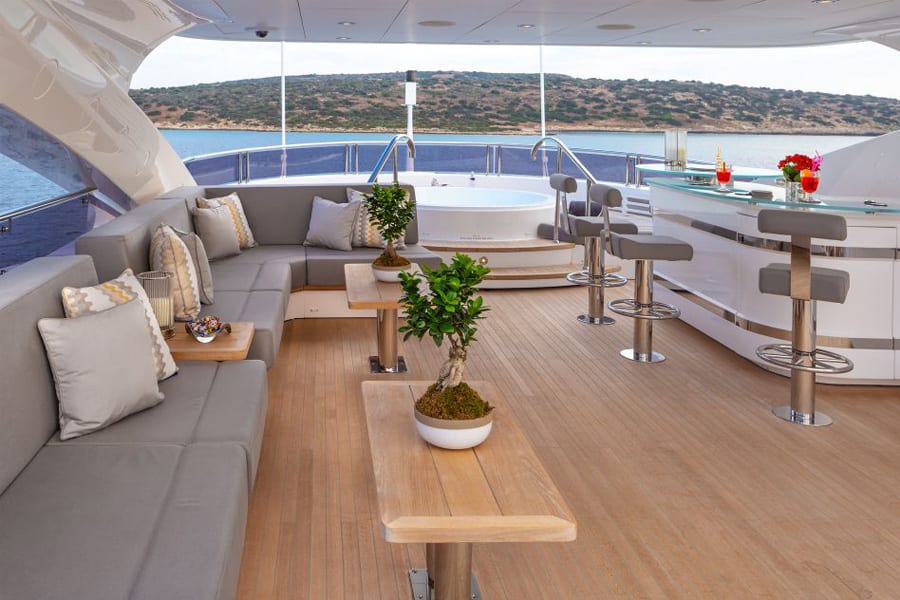 luxury yachts - deck of yacht with seating area and bar