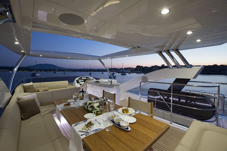 luxury yachts - deck of yacht with dining area at dusk
