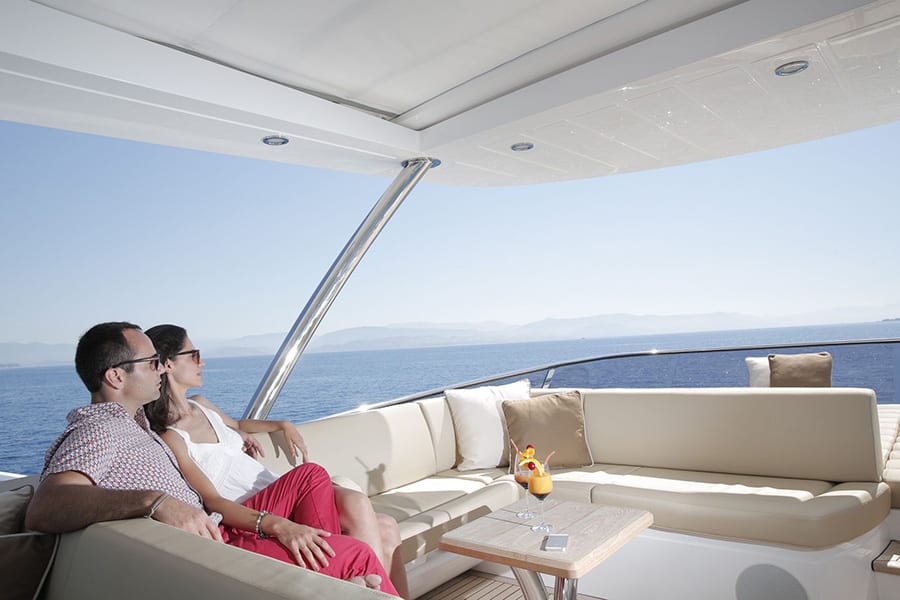 luxury yachts - couple enjoying view from lounge on deck of yacaht
