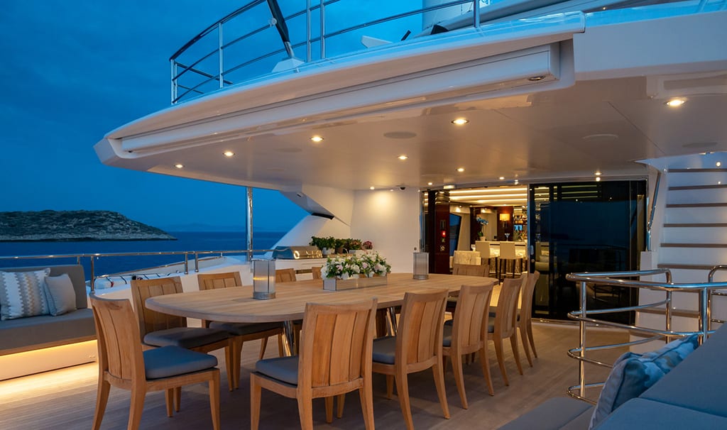 luxury yachts - outdoor dining area of yacht at dusk