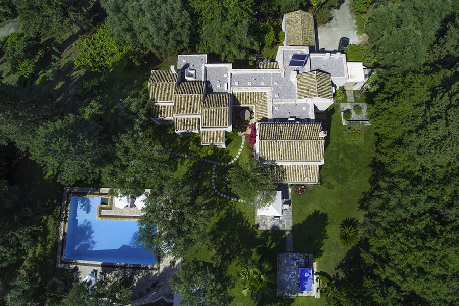 luxury villas - drone shot of villa in green surrounding with pool