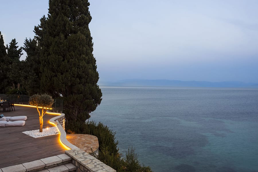luxury villas - view of terrace with relaxing sun beds and beautiful sea view at sunset
