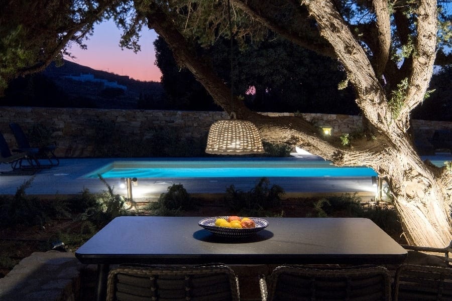 luxury villas - outside dining area with pool by night