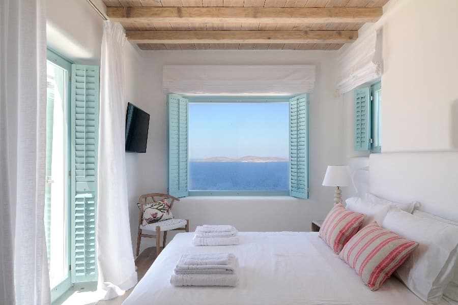 luxury villas - bedroom with double bed and open window with sea view