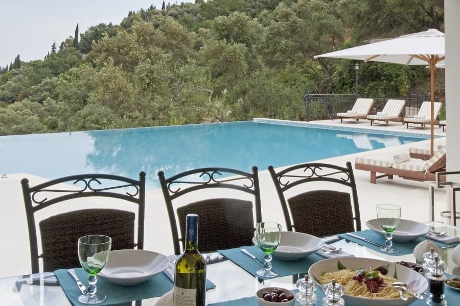 luxury villas - pool with sun beds and table with chairs and spaghetti with wine