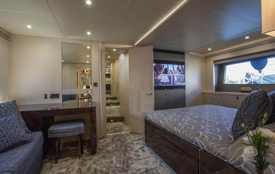 luxury yachts - bedroom of yacht with bed, seating area and television