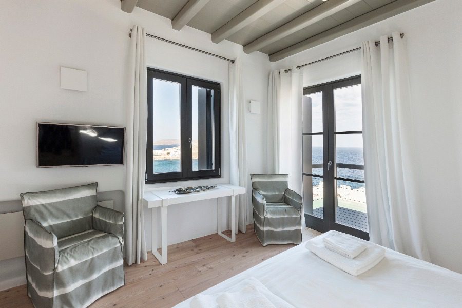 luxury villas - bedroom with armchairs and tv and sea view