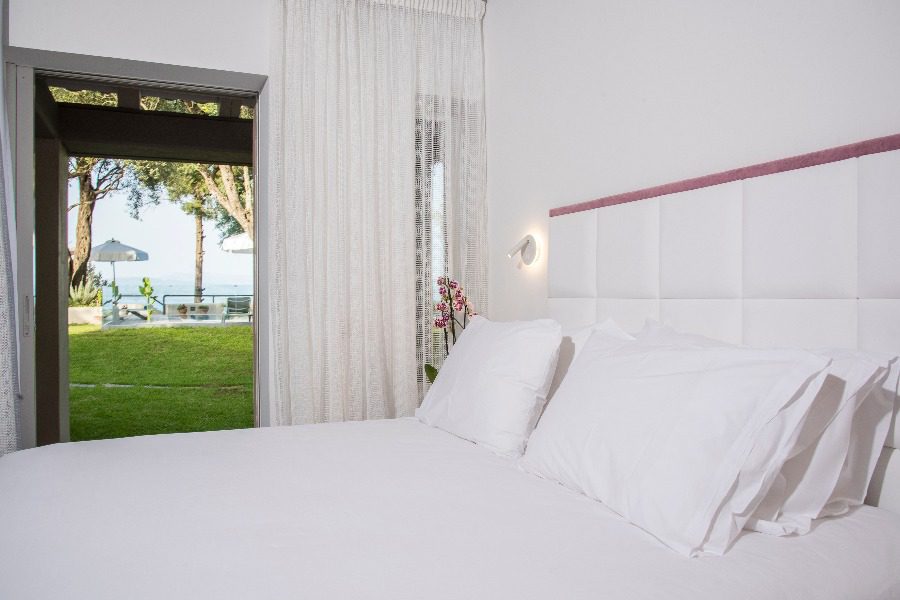 luxury villas - bedroom with double bed and white sheets with view to garden
