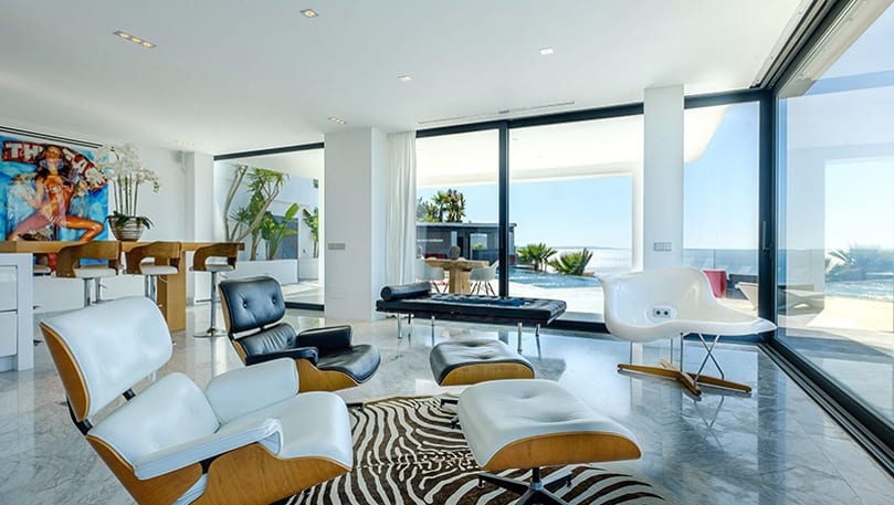 luxury villas - living room with marble floor and relaxing chairs with view to the terrace with pool