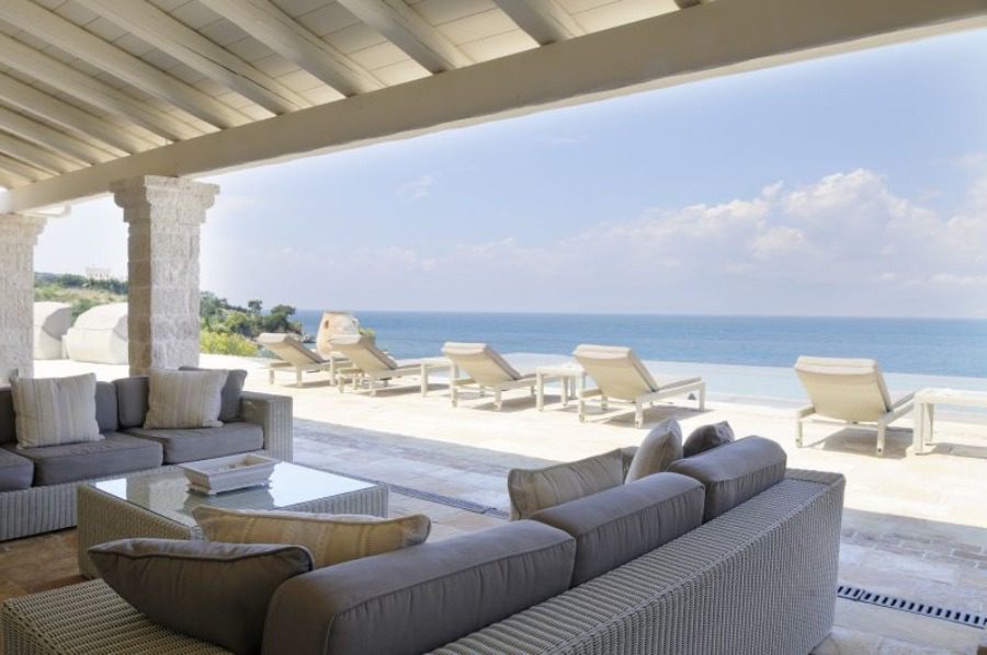 luxury villas - outside lounge with sun beds and pool with sea view