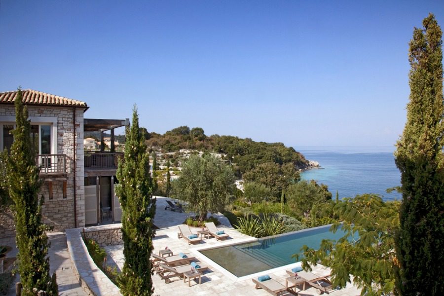 luxury villas - view to patio of the villa with sun beds and pool and beautiful sea view