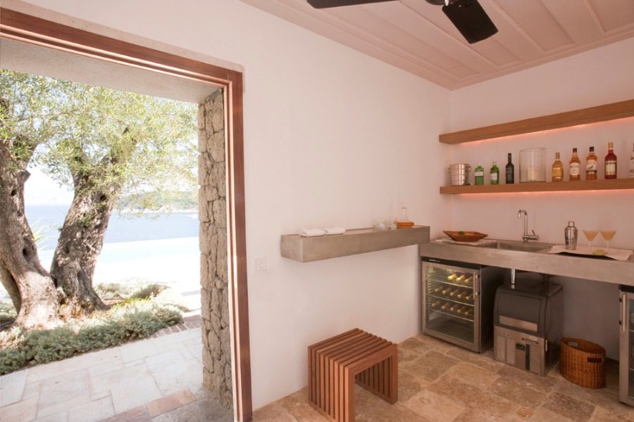 luxury villas - kitchen with open door to terrace with old tree and sea view