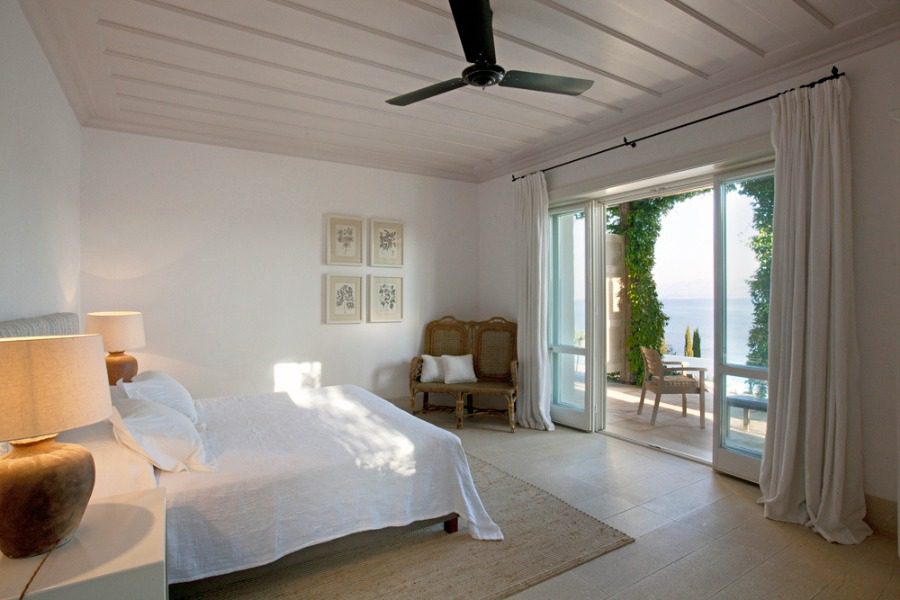 luxury villas - bedroom with open door to terrace with pool and sea view
