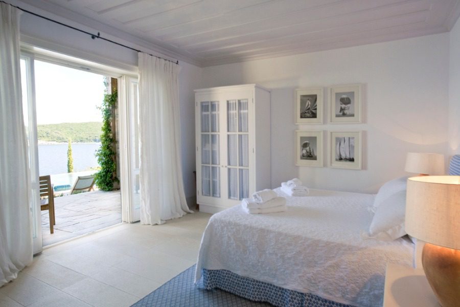luxury villas - bedroom with double bed and open door to terrace with sea view