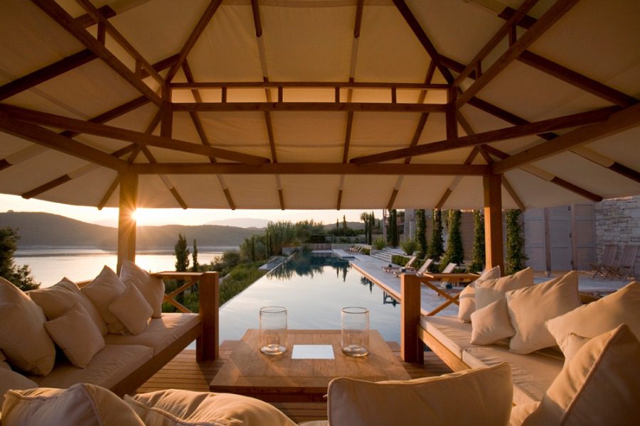 luxury villas - outside relaxing area with sofas and pool with sea view at sunset