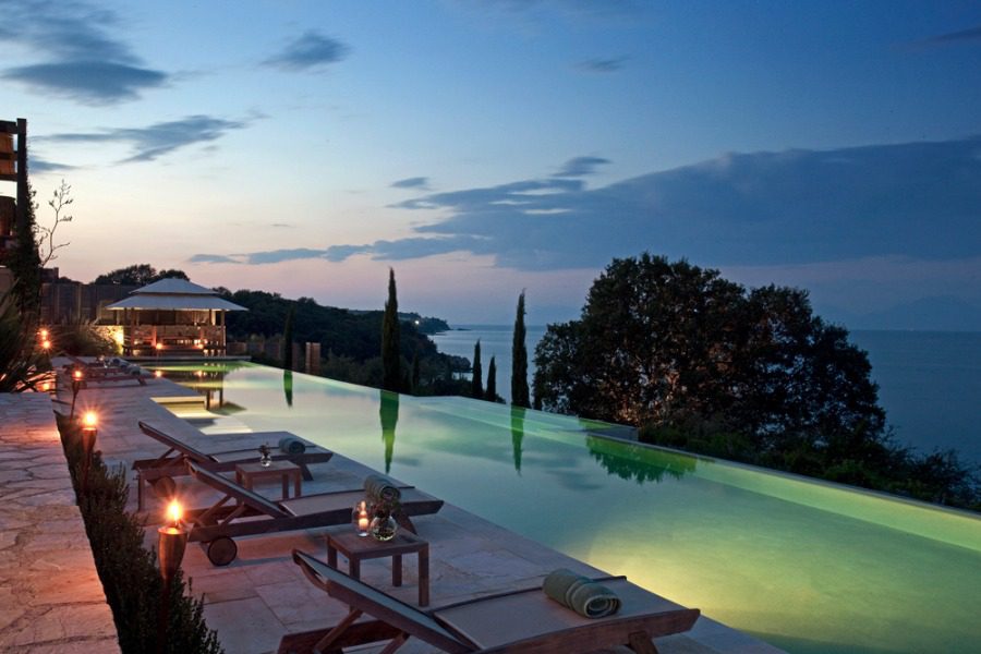 luxury villas - pool with sun beds and sea view by night