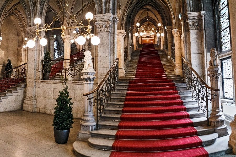 luxury experiences - imposing stairs in baroque building with red carpet