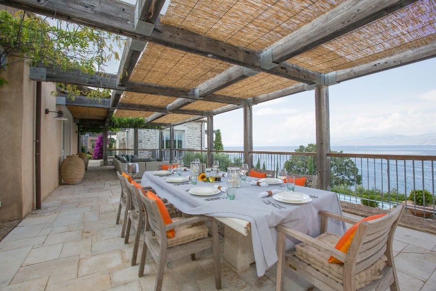 luxury villas - outside dining table with chairs and sea view