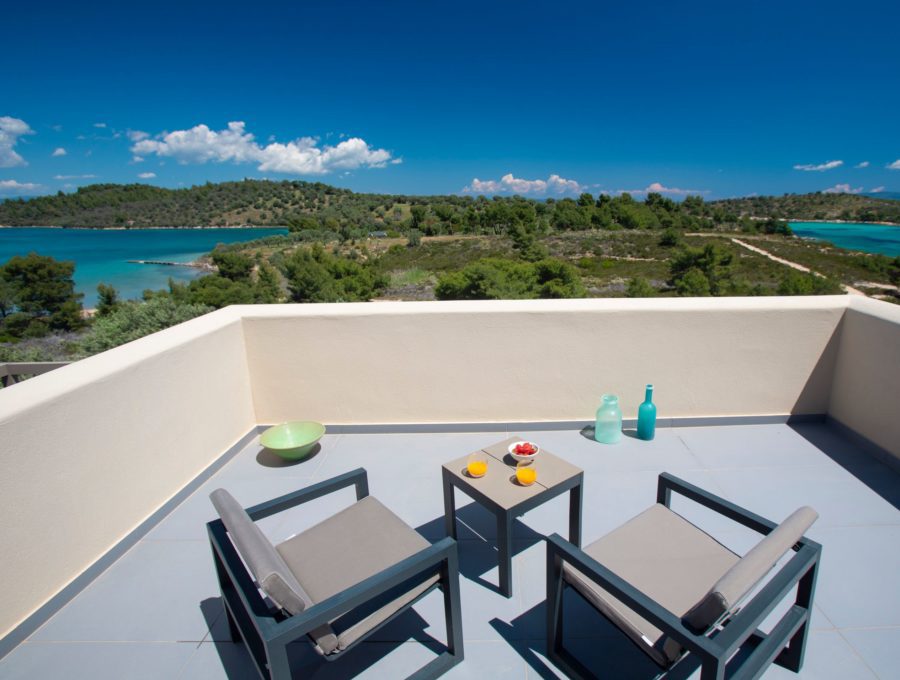 luxury villas - patio with chairs and table with orange juice and fruit with beautiful sea view