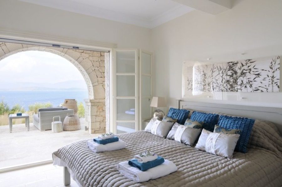 luxury villas - bedroom with double bed and archway to the balcony