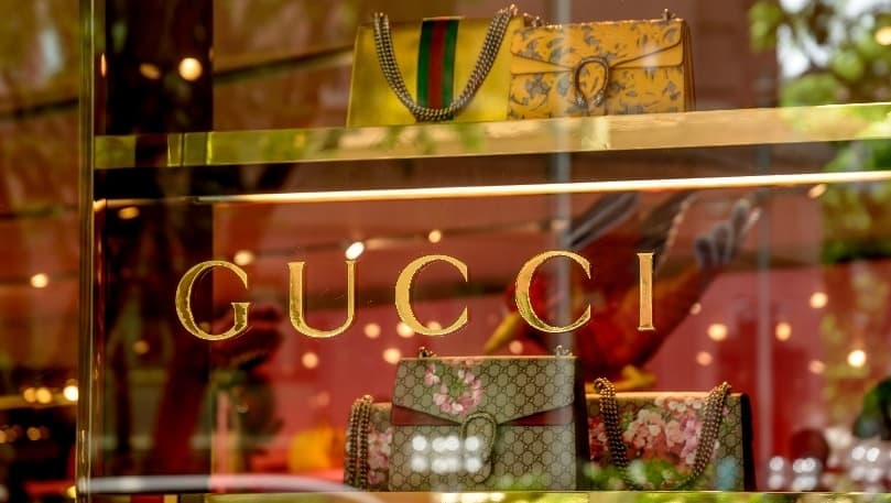 luxury services - gucci logo and handbags in a shop window