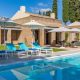 luxury villas - pool with sun beds and outside relaxing area with villa in the background