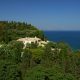 luxury villas - villa in green landscape with sea in the background