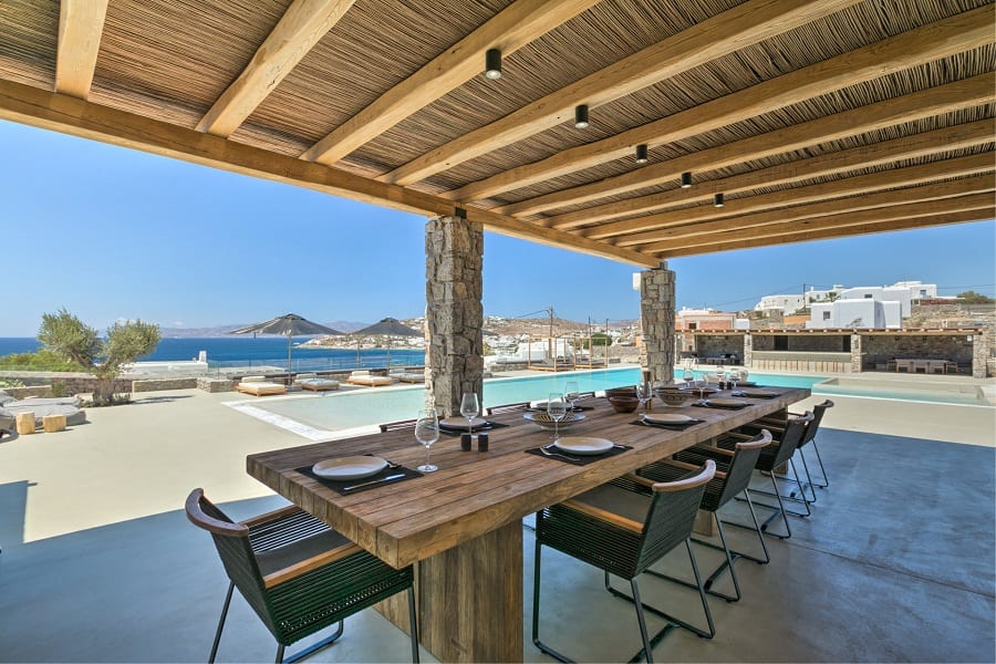 luxury villas - outdoor dining area with pool and sun beds with sea view
