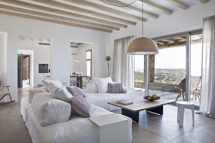 luxury villas - large living room with white couch and view to terrace and kitchen