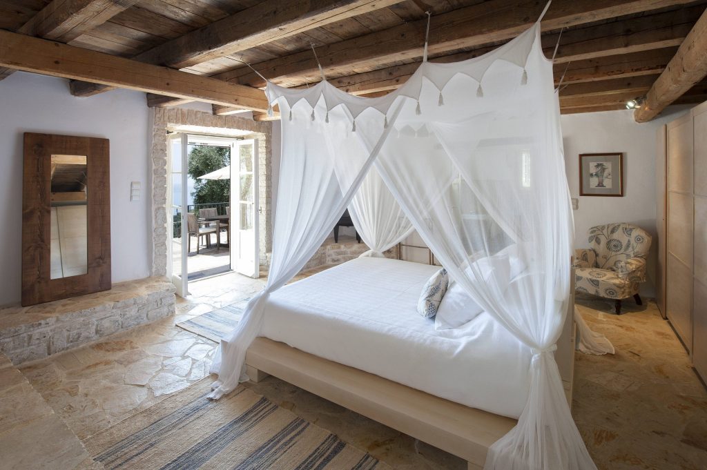 luxury villas - bedroom with canopy bed and open door to terrace
