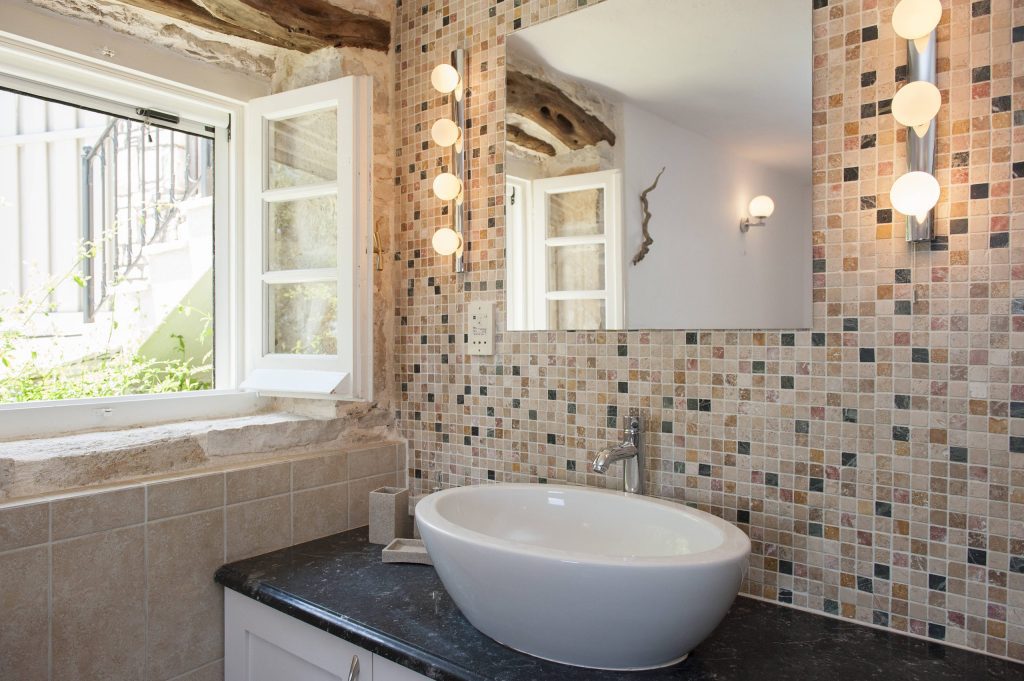 luxury villas - bathroom with sink and brown mosaic tiles