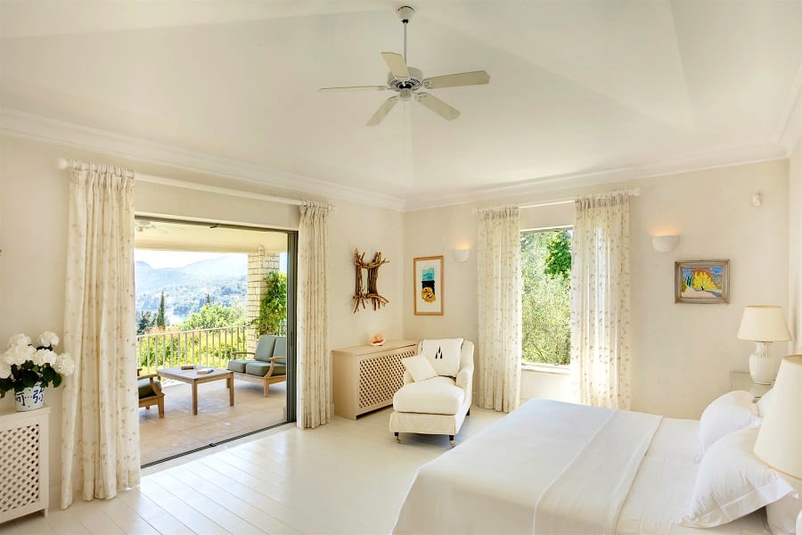 luxury villas - bright bedroom with double bed and armchair and view of the terrace