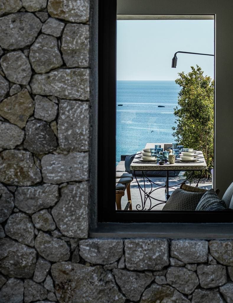 luxury villas - view through window to the outside dining area and the sea