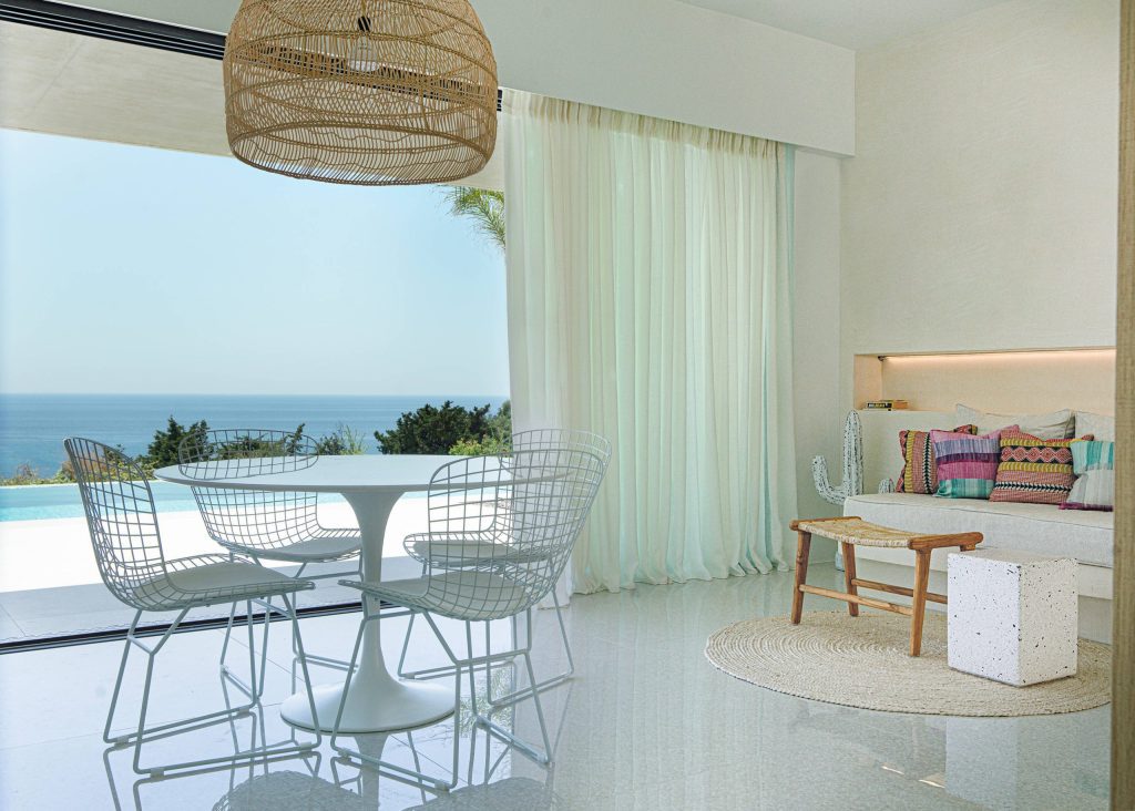 luxury villas - white living room with view to the pool and the sea