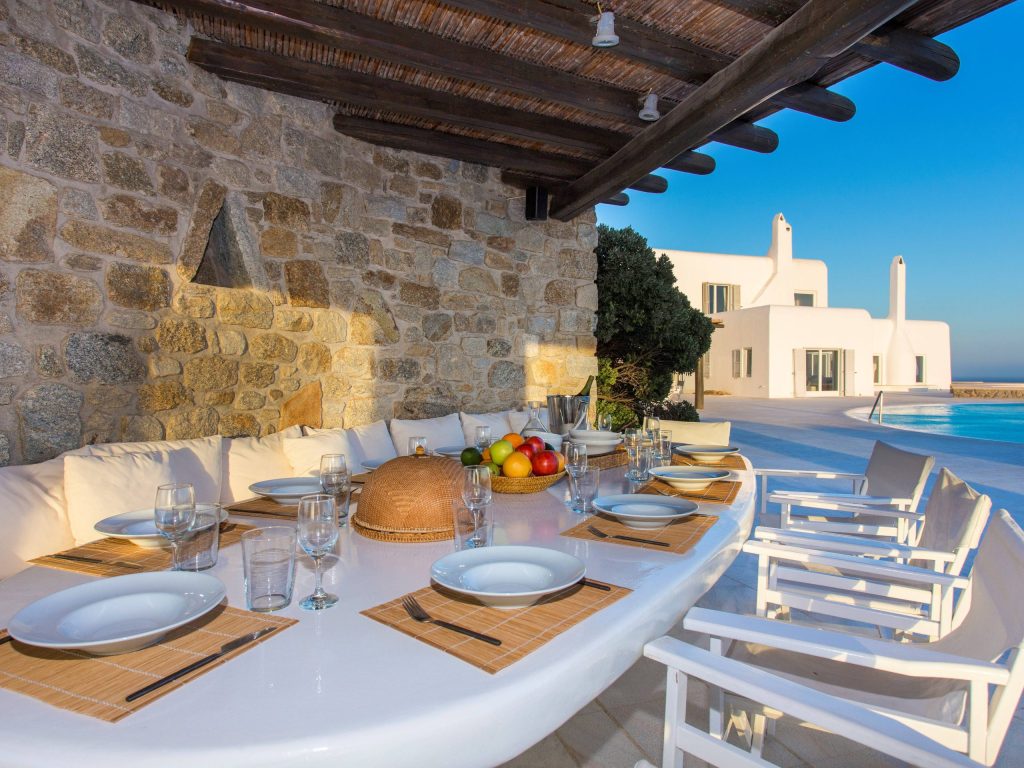luxury villas - outdoor dining area with pool in the background