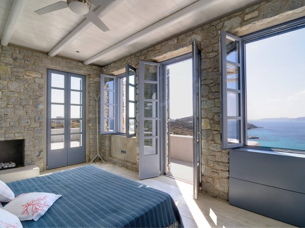 luxury villas - bedroom with open door and windows with access to the terrace and seaview