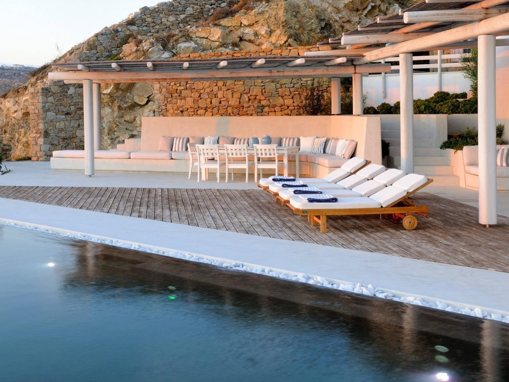 luxury villas - outside relax area in the sunset with sunbeds and pool